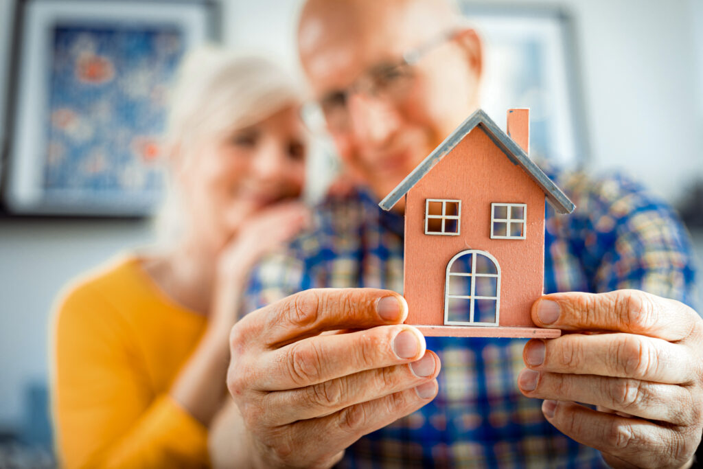 Older couple looking at a model of a smaller house