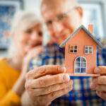 Older couple looking at a model of a smaller house