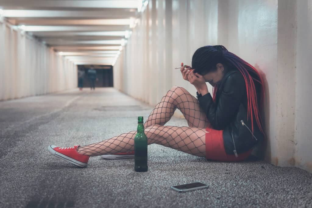 Depressed homeless girl in deserted hallway