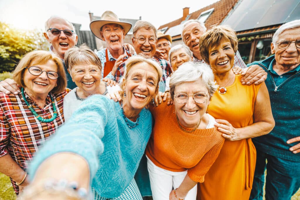 Group of seniors all smiling and holding arms outstretched towards camera