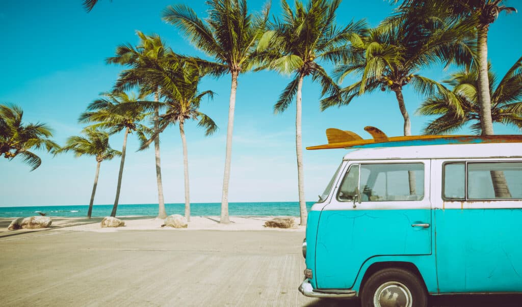 Older Volkswagen bus or van at a beach for surfing
